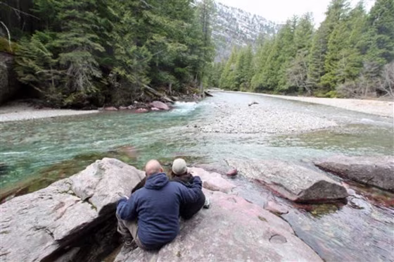 A&nbsp;couple sits on a rock as they look at scenery at Glacier National Park in Montana.